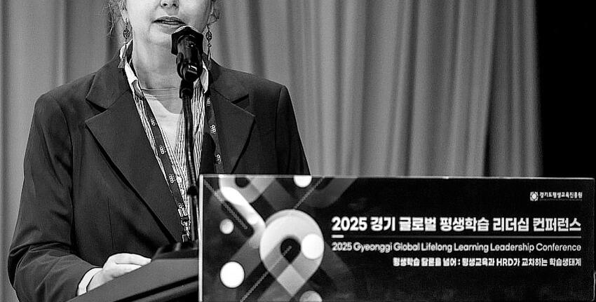 A woman stands at a conference lectern